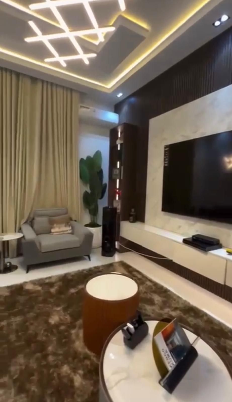 A living room with a large flat screen tv on the wall.