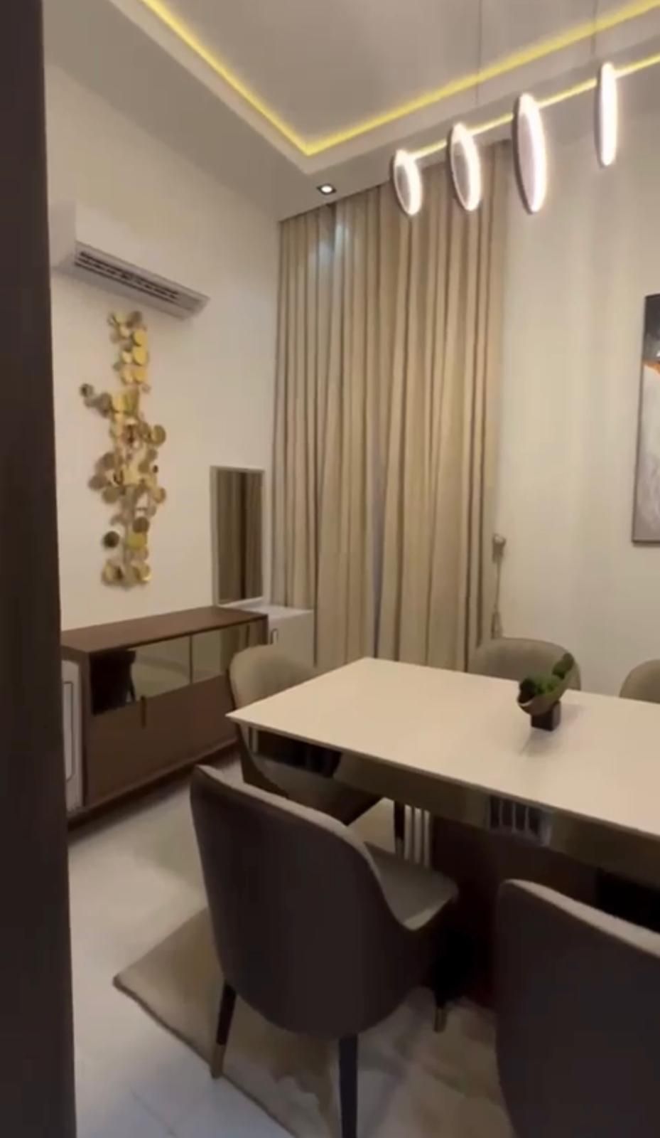 A living room with a couch , chair , table and television.