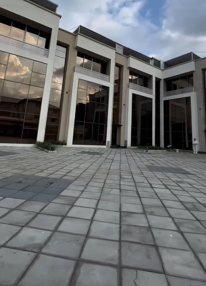 A large building with a lot of windows and a brick walkway in front of it