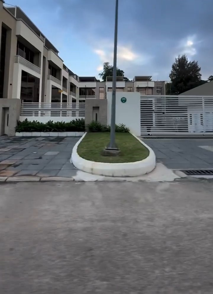 A building with a fence and a grassy area in front of it