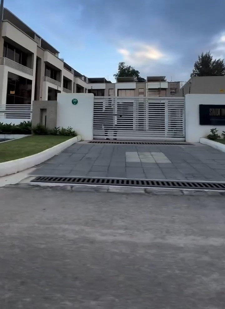 A driveway leading to a building with a sliding gate