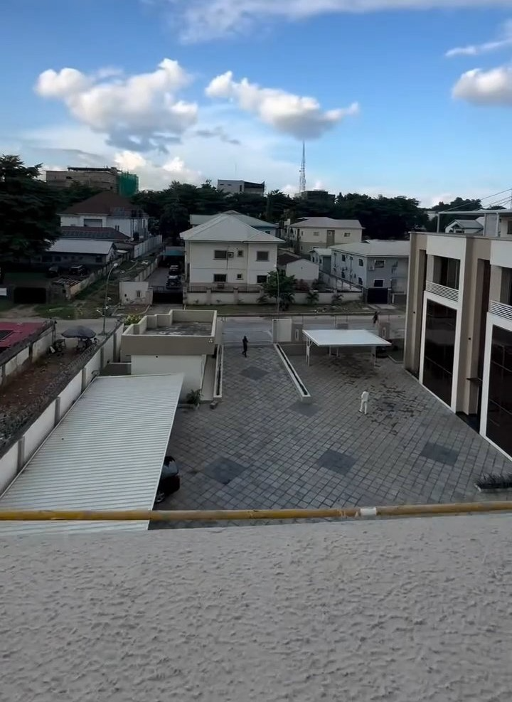 An aerial view of a building with a lot of cars parked in front of it.