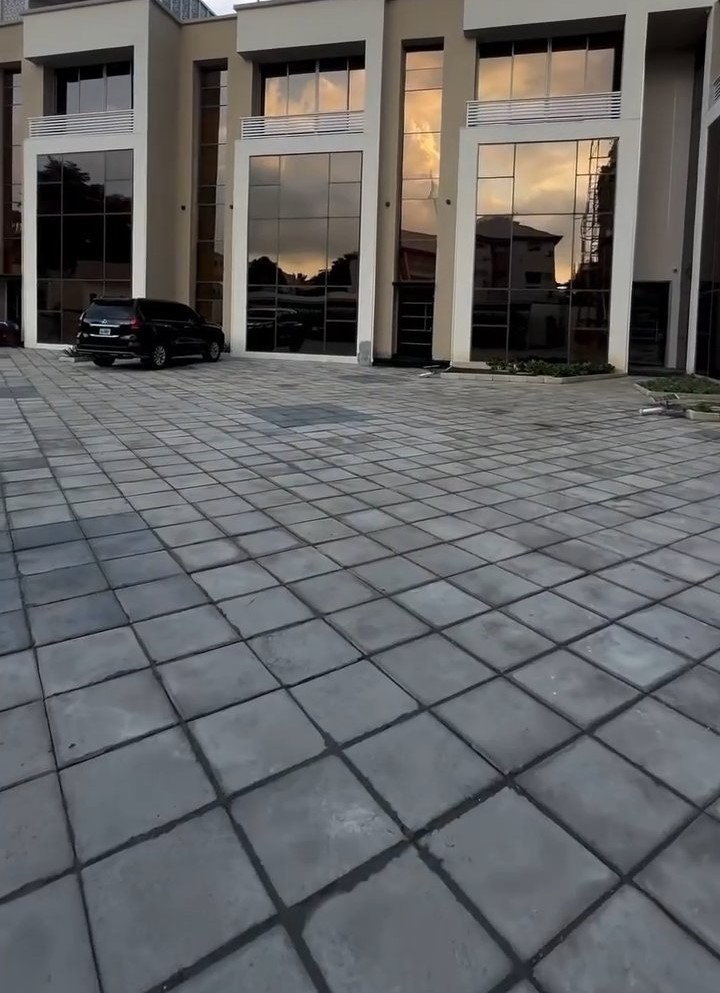 A car is parked in front of a building with a lot of windows.