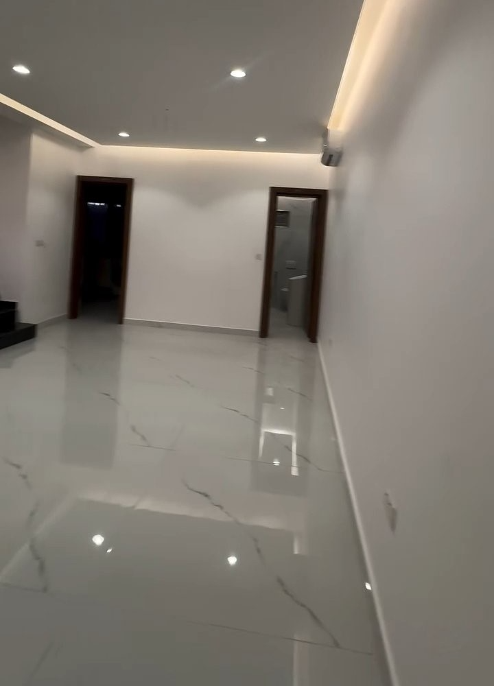 A hallway with a marble floor and white walls