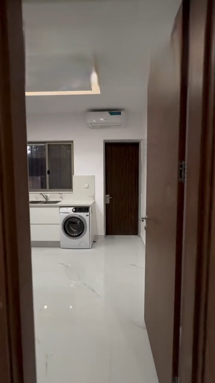 A room with a washing machine and a sink in it.