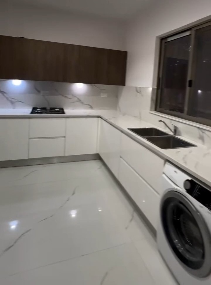 A kitchen with white cabinets and a washing machine