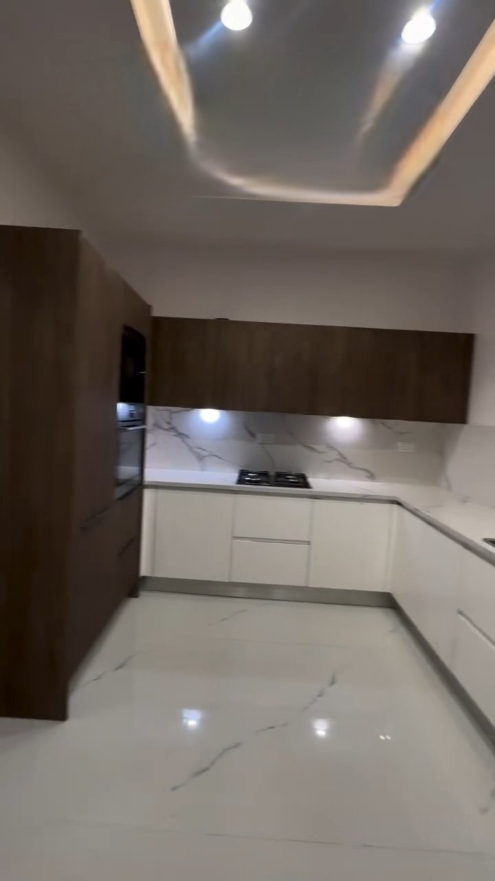 A kitchen with white cabinets and a stove top oven.
