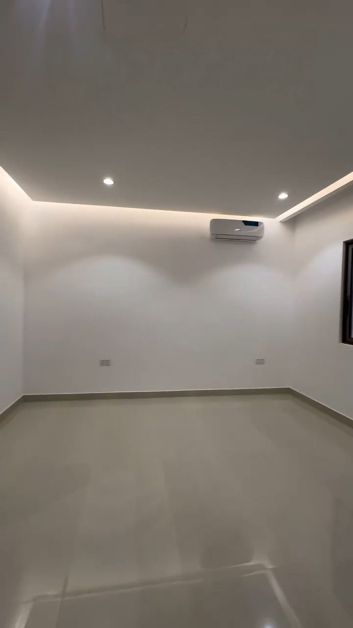 A large empty room with white walls and a window.