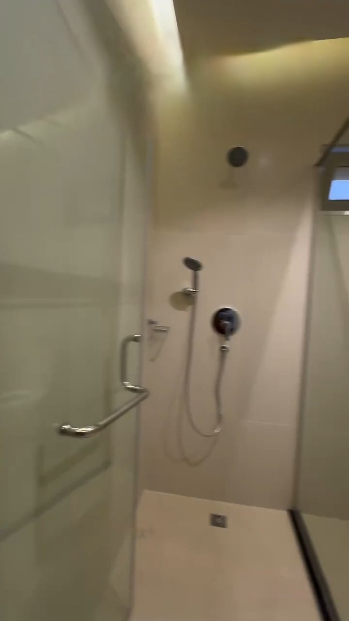 A shower with a glass door and a shower head