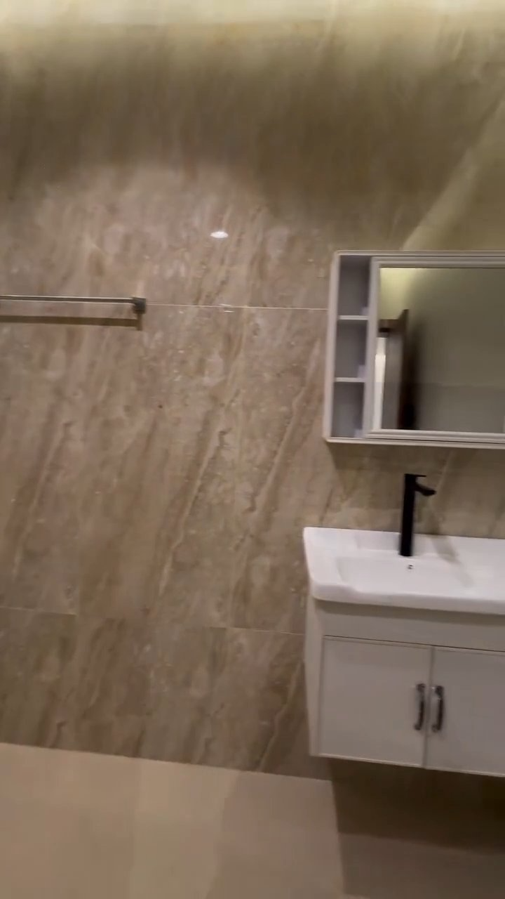 A bathroom with a sink , mirror and towel rack.