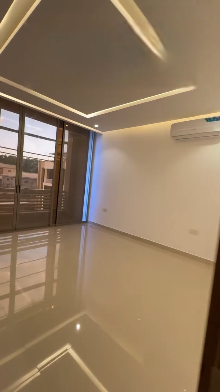 A large empty room with a lot of windows and a ceiling light.
