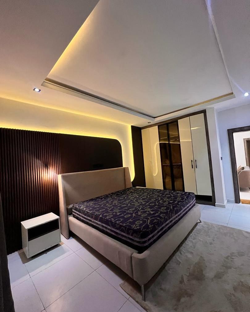 A bedroom with a large bed and a nightstand