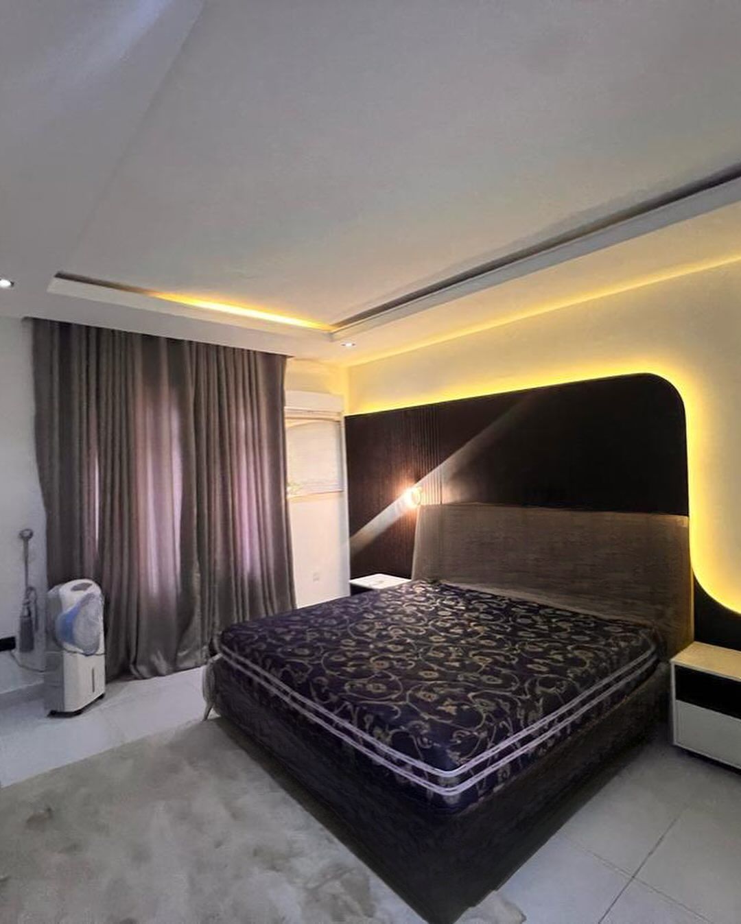 A bedroom with a large bed and a nightstand