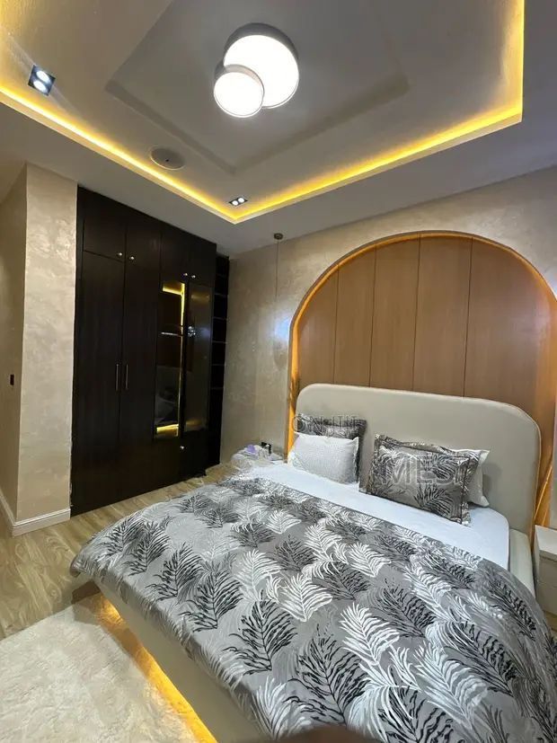 A bedroom with a large bed and a ceiling light.