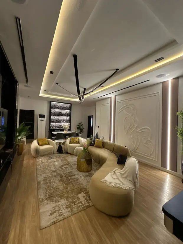 A living room with a couch , chair , table and television.