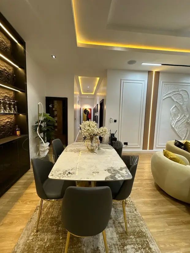 A dining room table and chairs in a living room.
