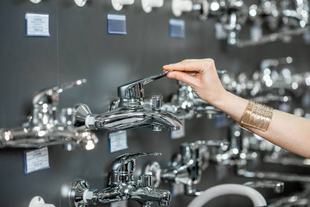 A close-up of a woman’s hand selecting a sanitary tap at Madison Heights Plumbing & Heating Supply in Royal Oak, MI.