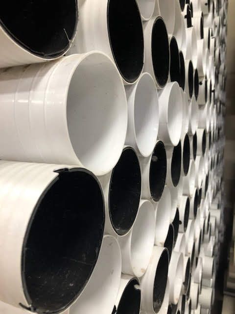 A stack of white pipes with black holes in them
