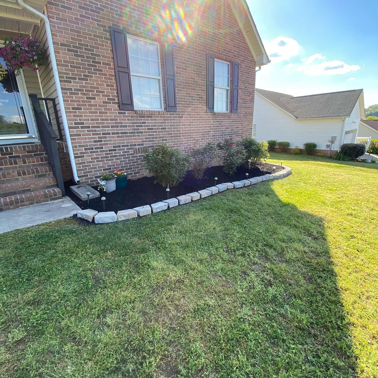 New landscape bed with fresh mulch, plants, and paver border
