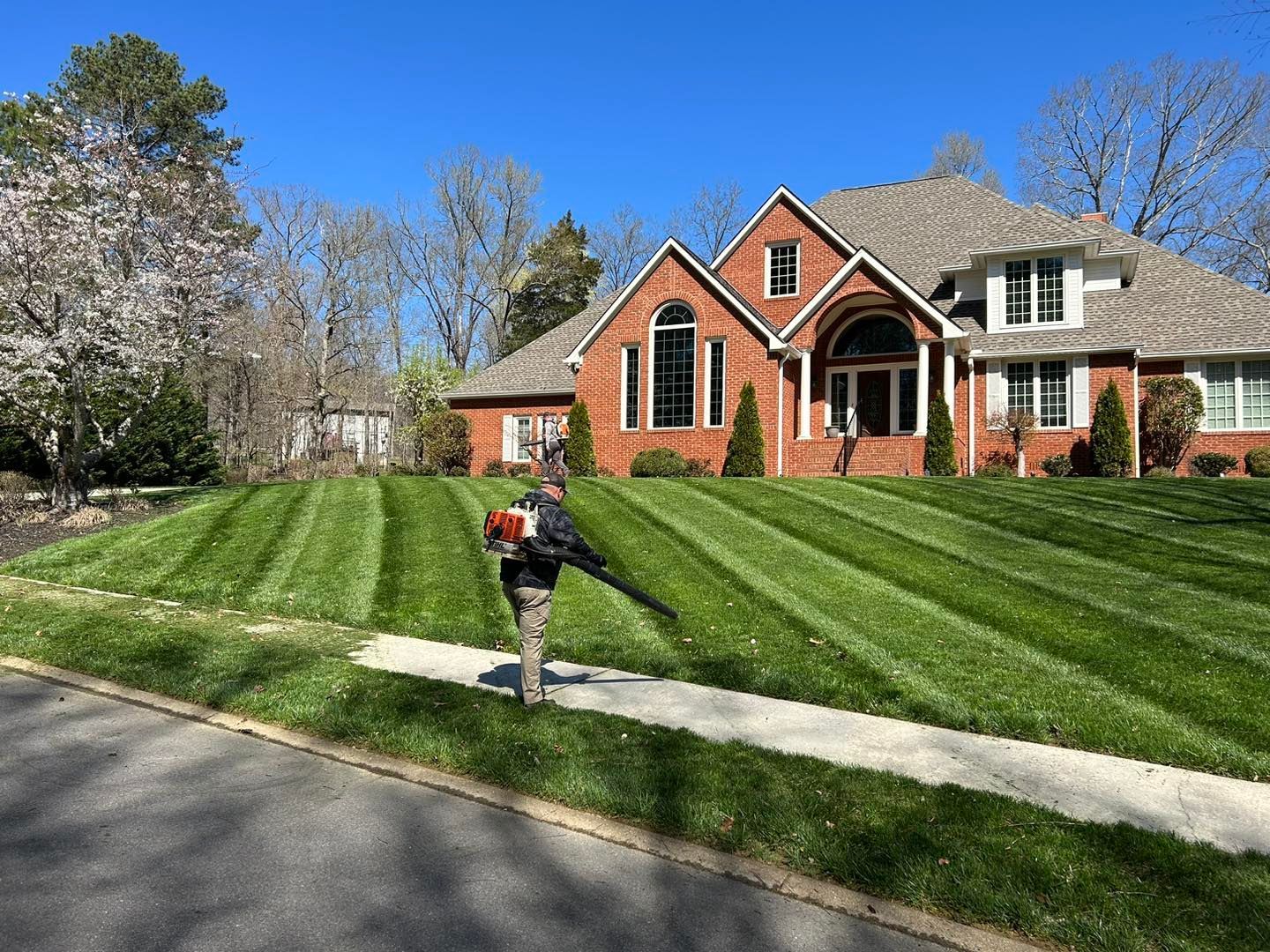 Professional lawn mowing service with clean striped finish. 