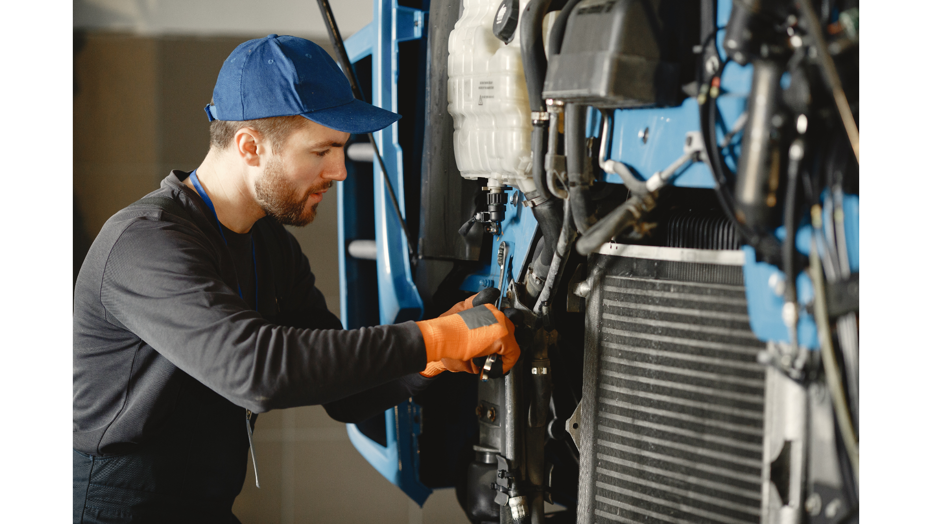 A man is working on a truck in a garage.
