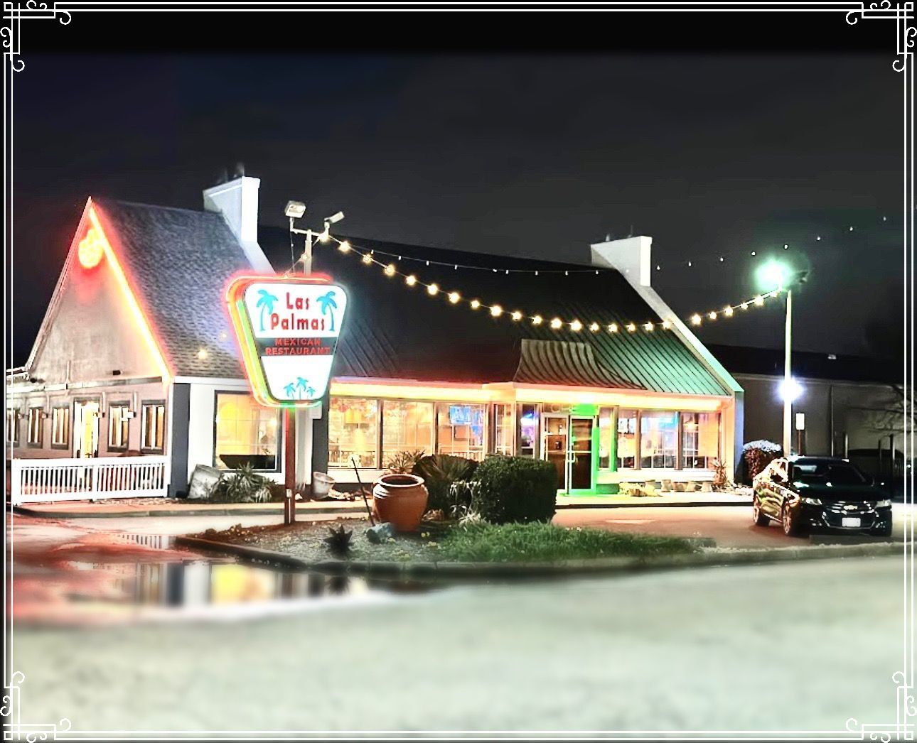 Las Palmas restaurant at night, illuminated sign, string lights, parked car.