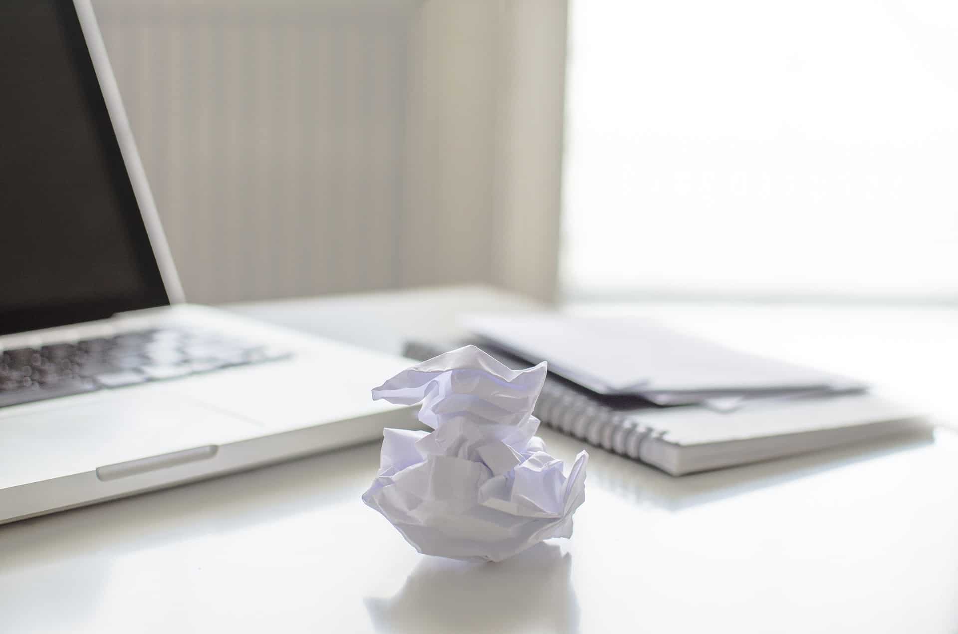 Crumbled paper besides laptop