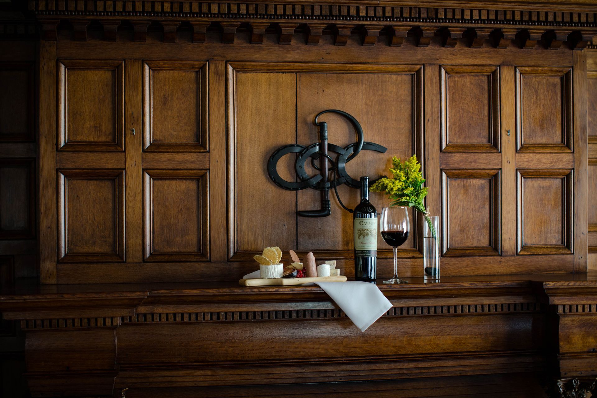 Wooden wall with wine, snacks, and a bouquet.