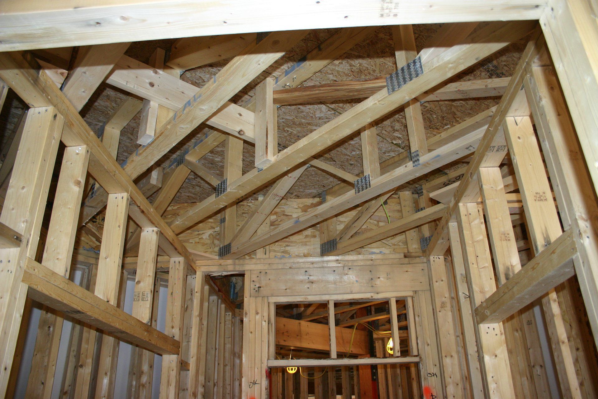 Exposed wooden roof trusses framing a house under construction