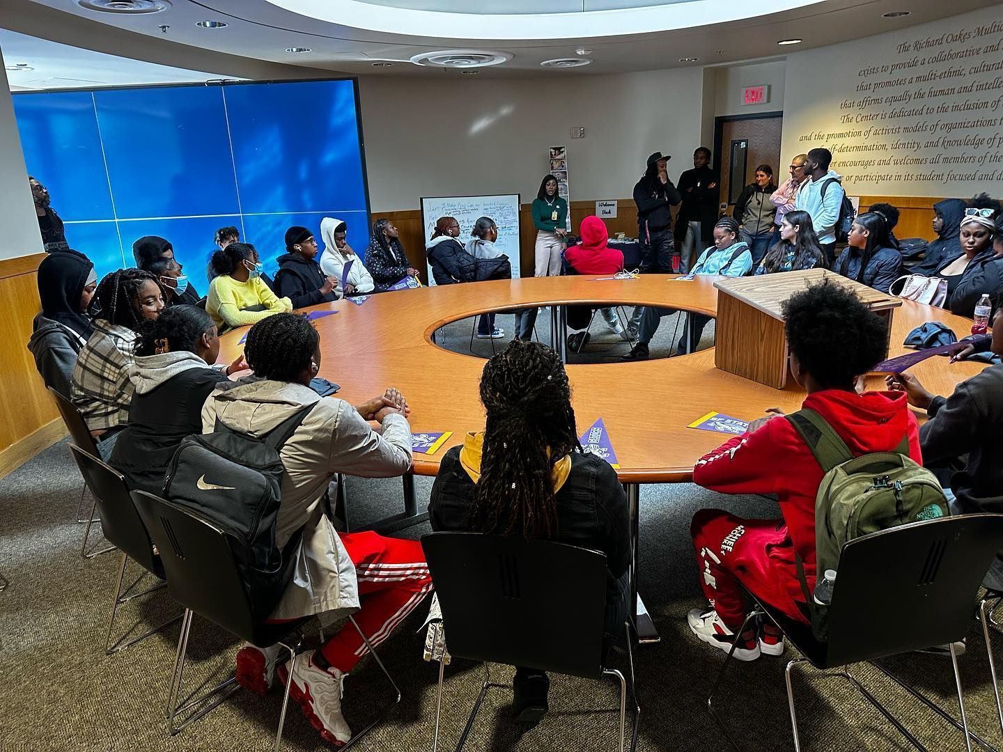 A group of people are sitting around a table in a conference room.