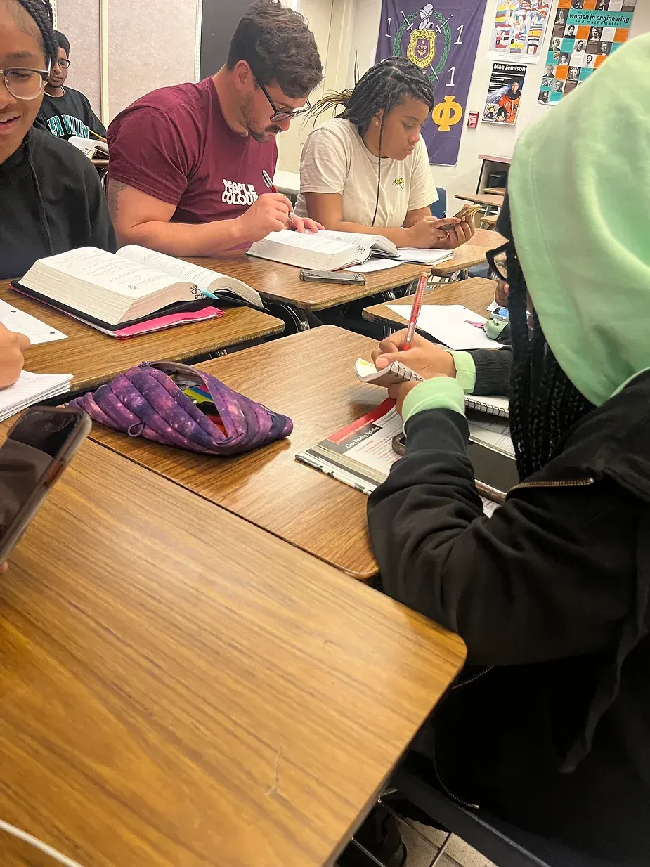 A group of students are sitting at desks in a classroom.