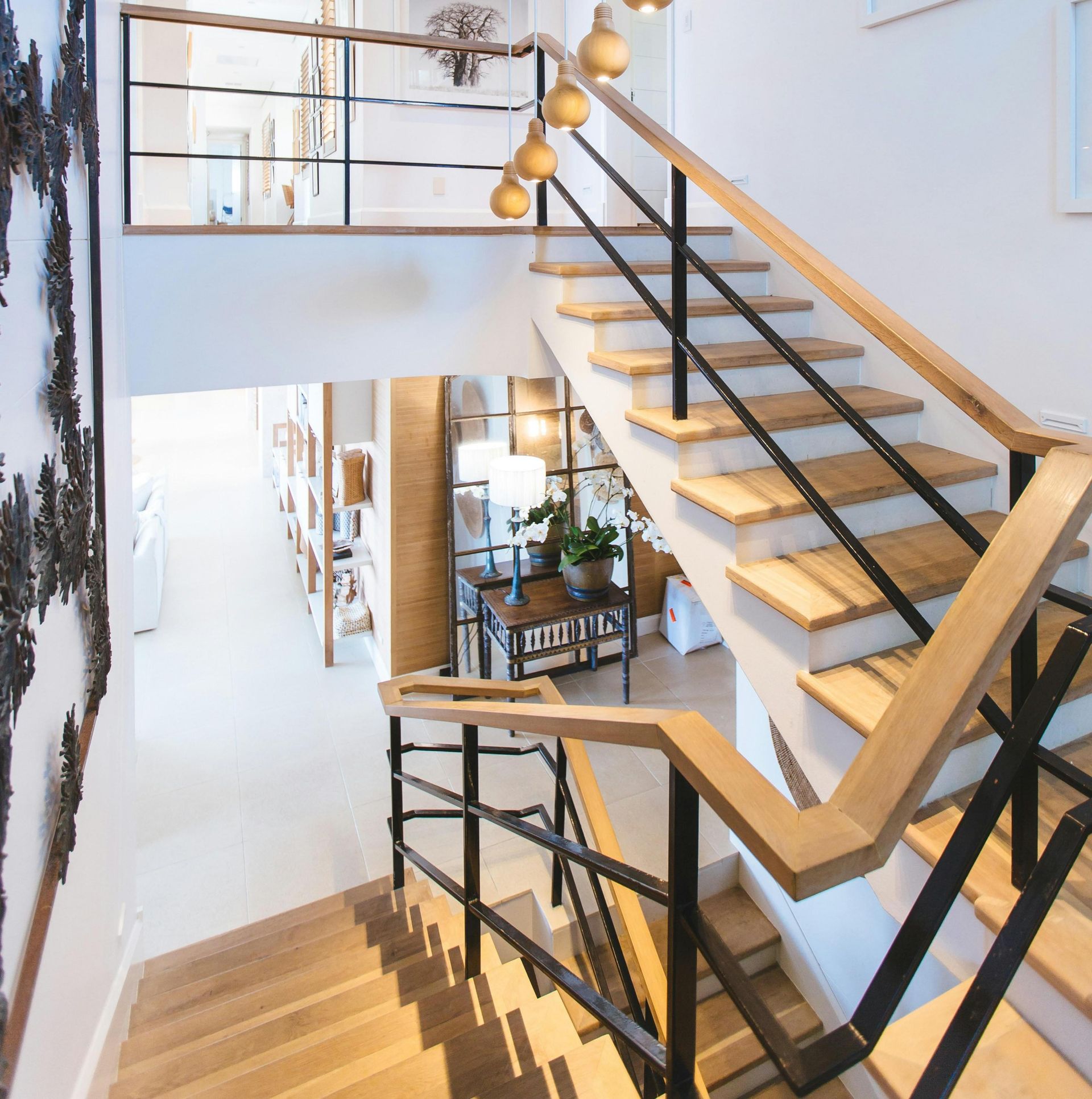 Modern indoor staircase with wood steps and black railings in a Town ‘n’ Country home.