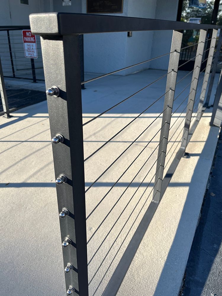 Detailed look at a black metal railing with a focus on cable tension
