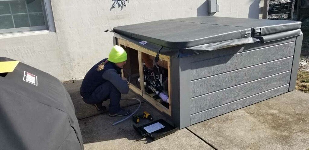 Man maintaining a hot tub outdoors during a sunny afternoon