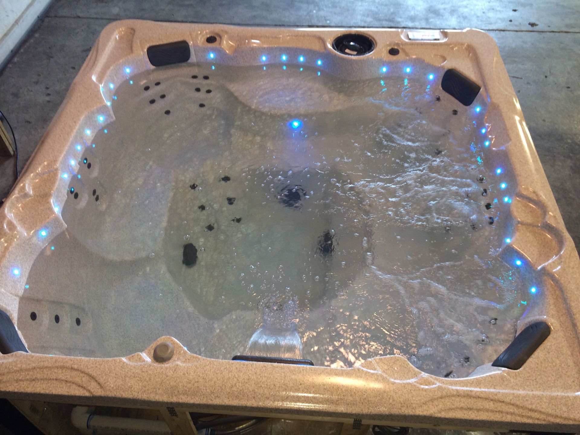 Hot tub with blue lights and water jets.