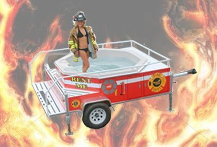 Firefighter in bikini stands in hot tub on a trailer, with a fiery background.