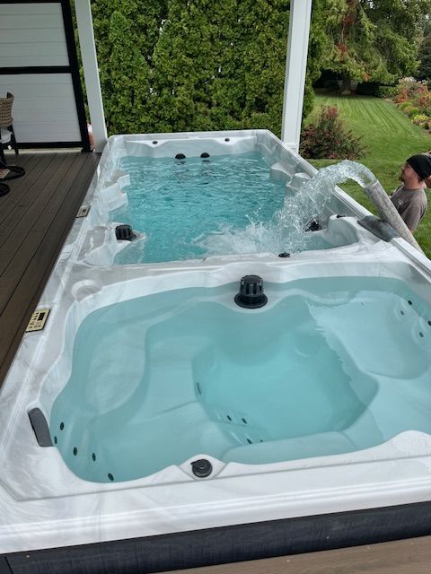 A dual swim spa on a deck, with jets and a woman pouring water.