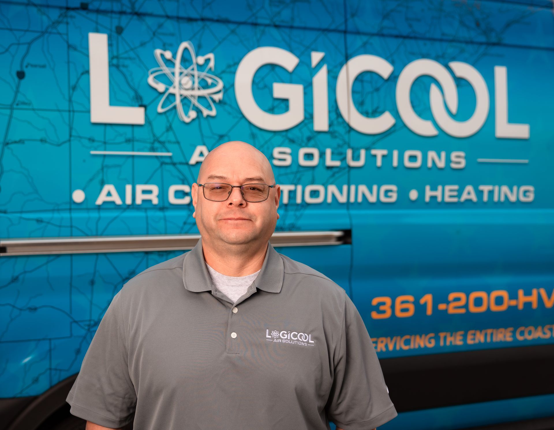 Man standing in front of a blue LogiCool Air Solutions heating and air conditioning sign