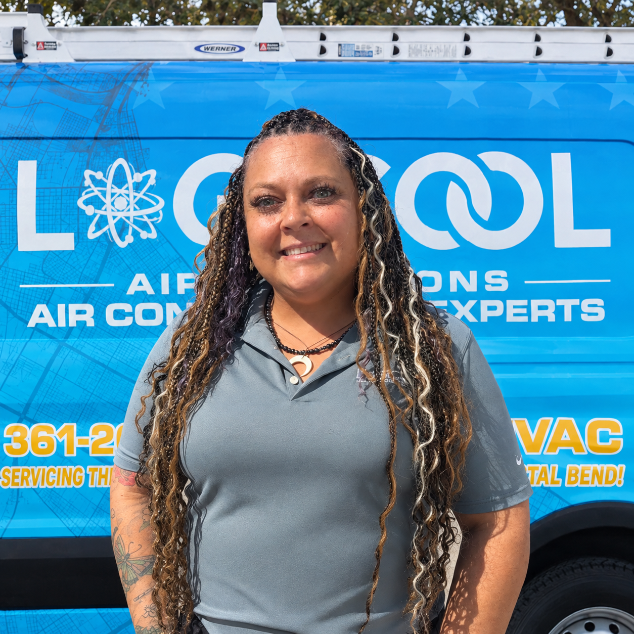 Woman in a gray polo standing in front of a blue LGICOL Air Solutions service van.
