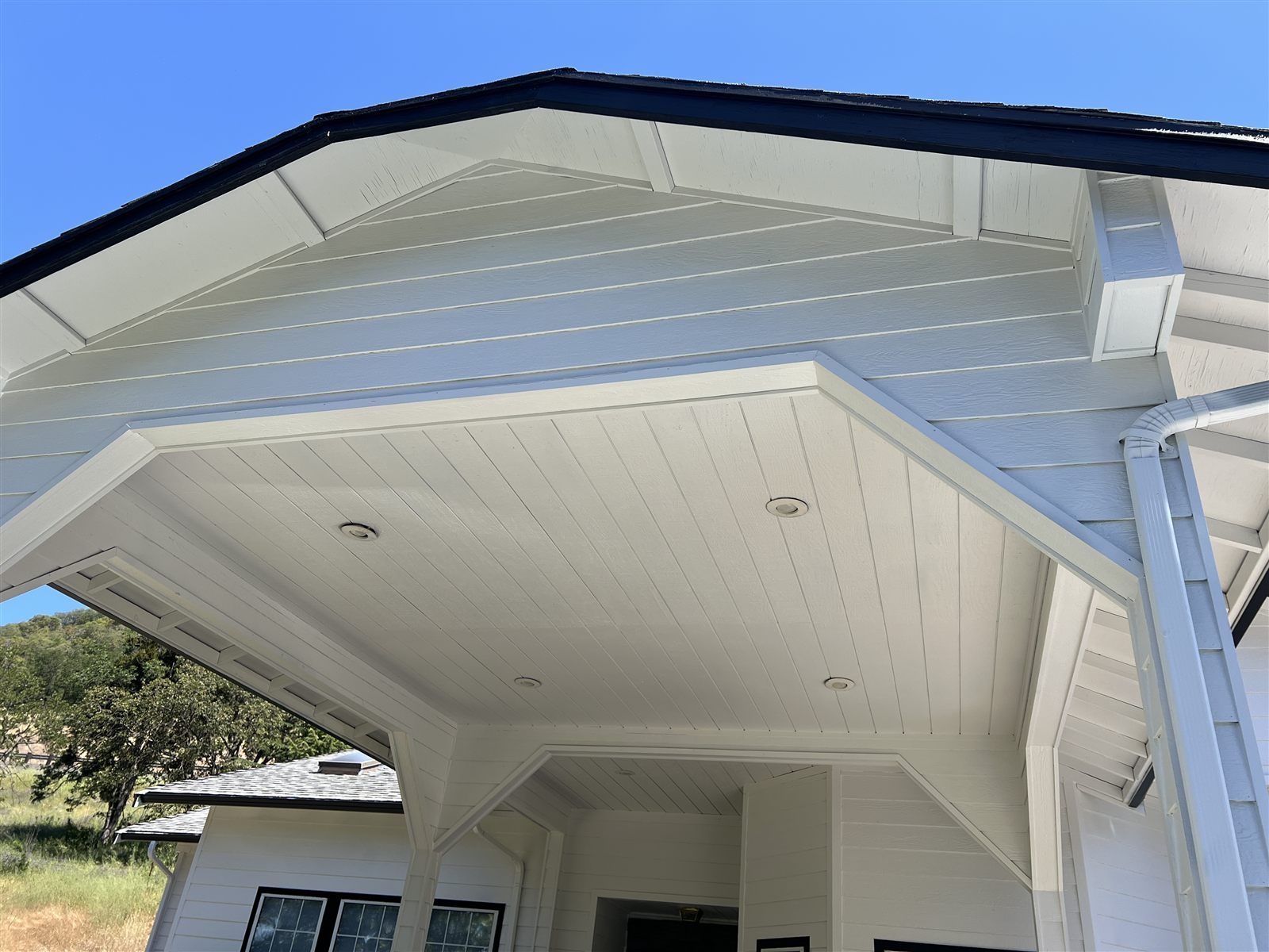 Covered-entry beadboard ceiling after repaint, painted white with black fascia