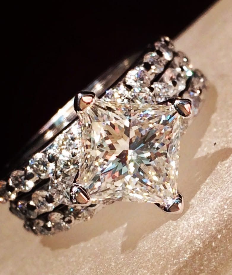 Close-up of a silver ring with a large diamond center and smaller diamonds along the band