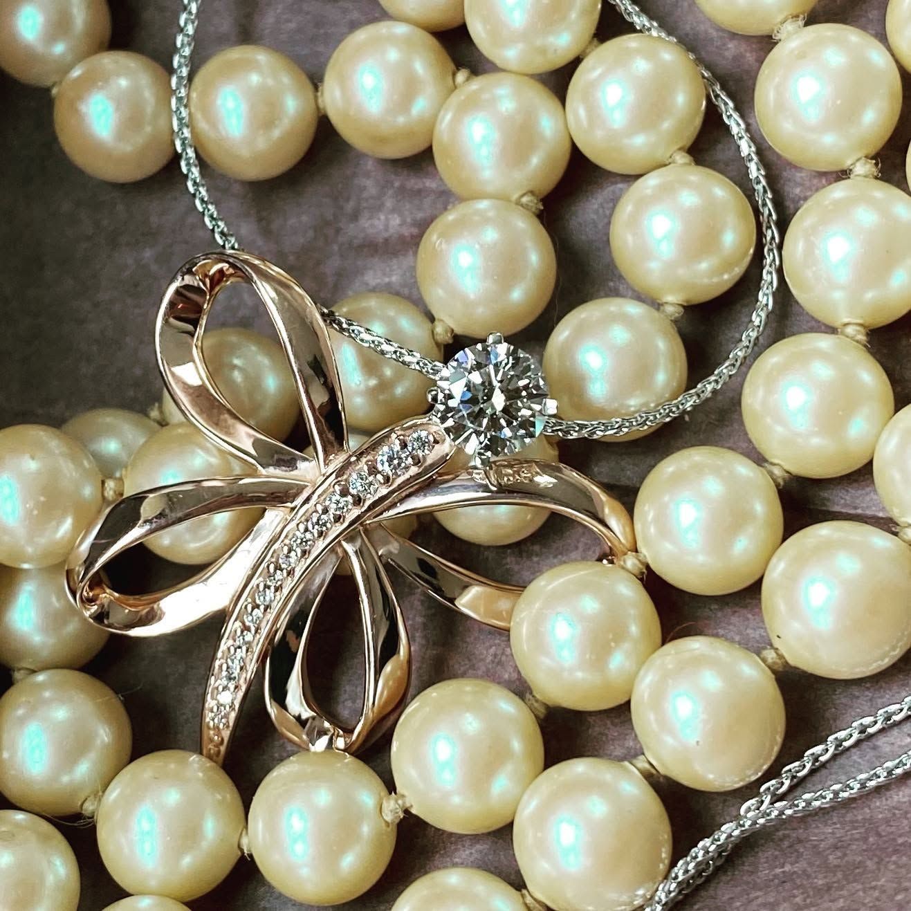 Pearl necklace with a silver bow brooch accented by clear stones