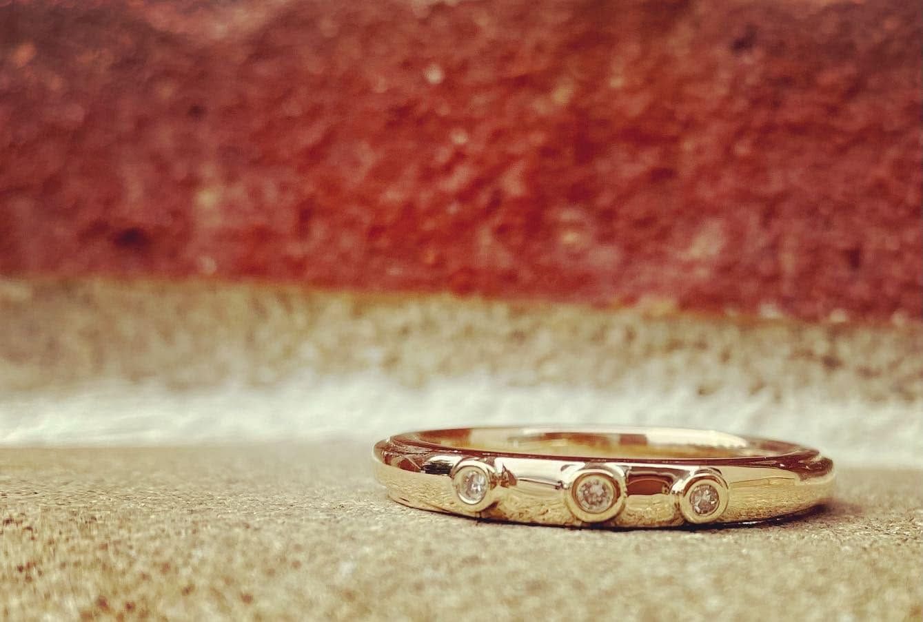 Gold ring on beige fabric with a red background