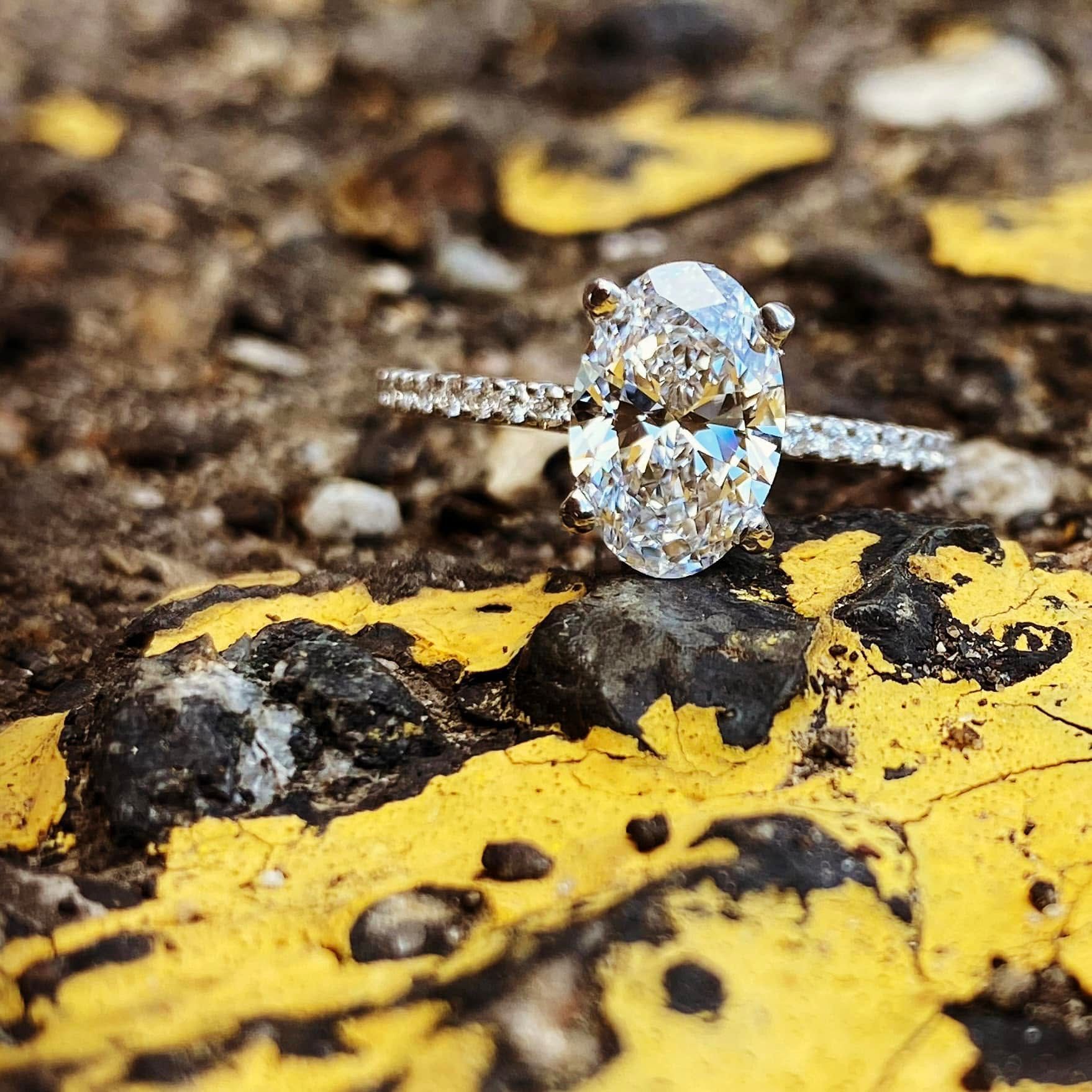 Oval diamond ring on a yellow-and-black textured rock surface