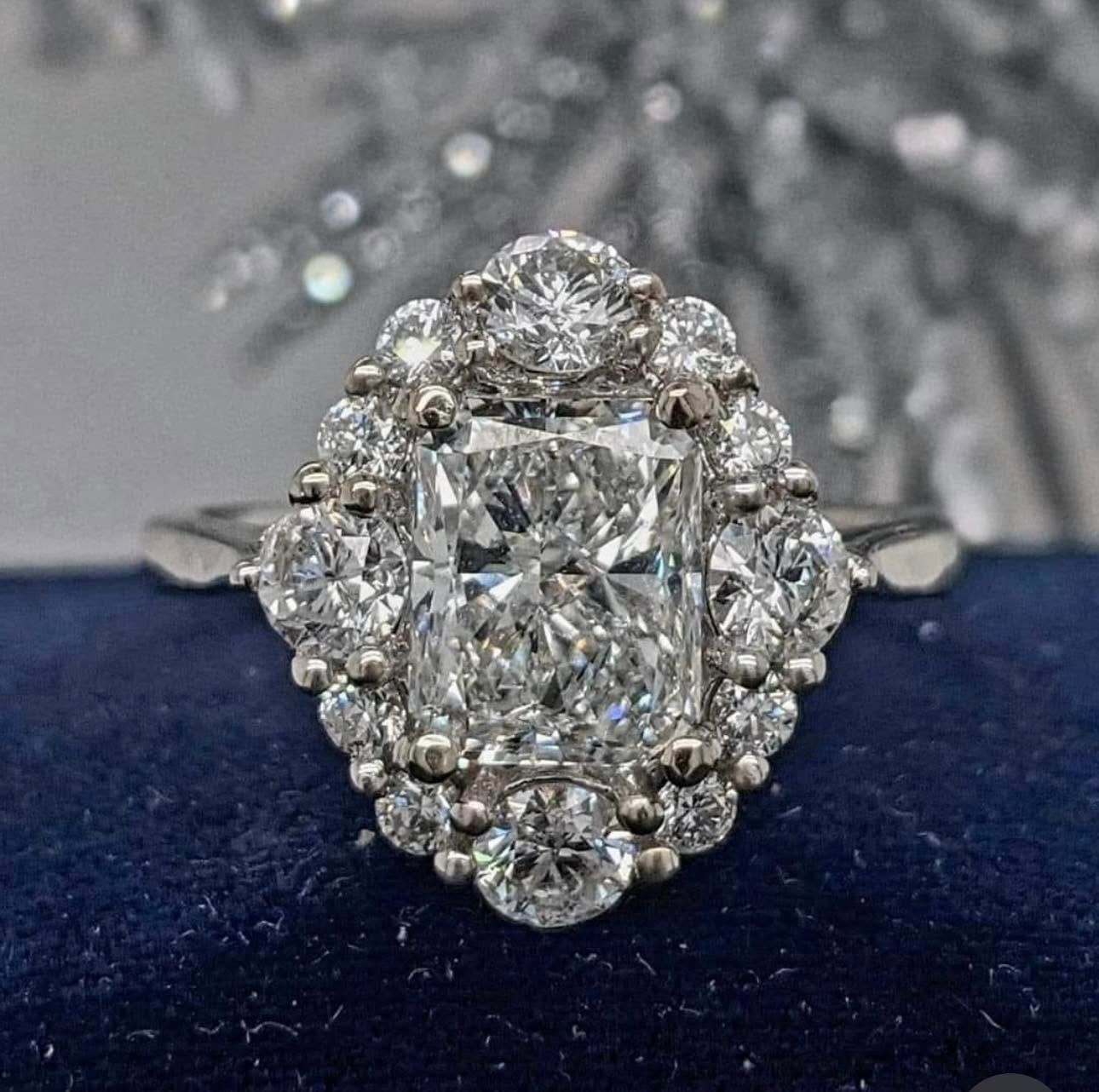Oval diamond halo engagement ring on a dark blue velvet surface