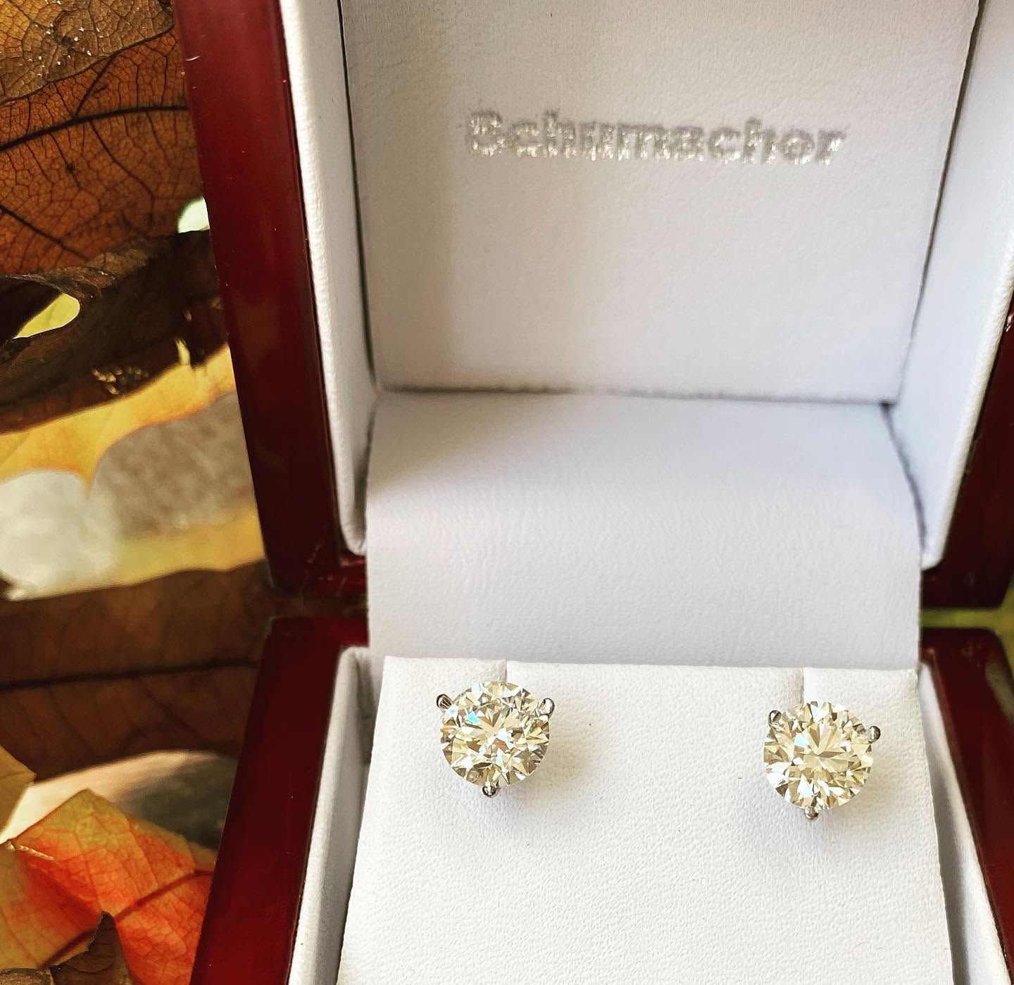 White jewelry box with a pair of gold stud earrings inside