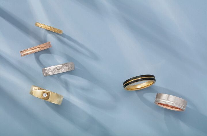 A group of rings are sitting on top of a blue cloth.