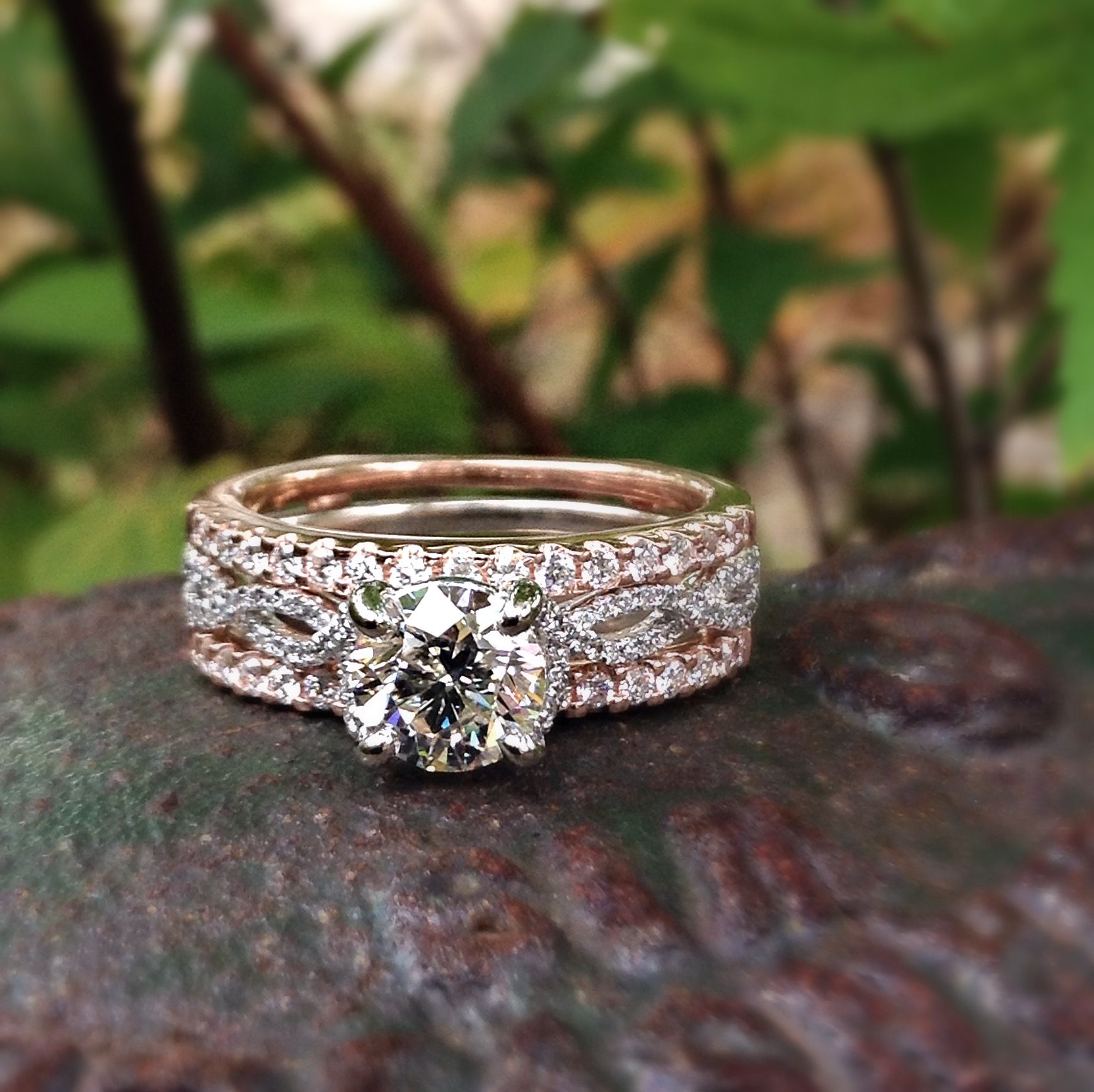 A ring with a diamond in the center is sitting on a rock