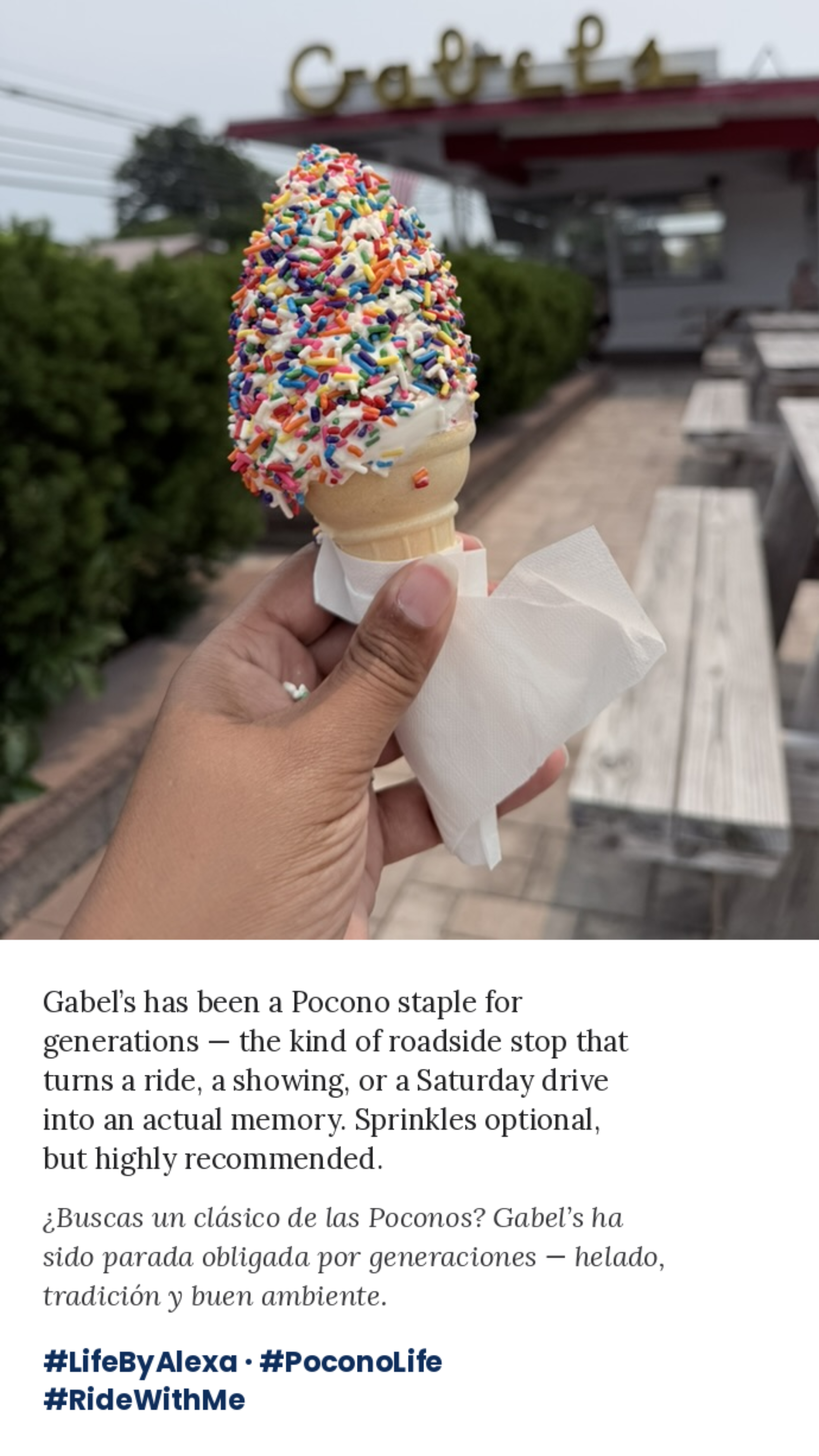 Hand holding sprinkle-covered ice cream cone in front of Gabels, a restaurant patio