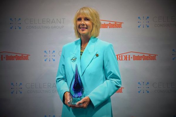Laura Emmons from Nu-bird Inc.holds an award at RDH Under One Roof.